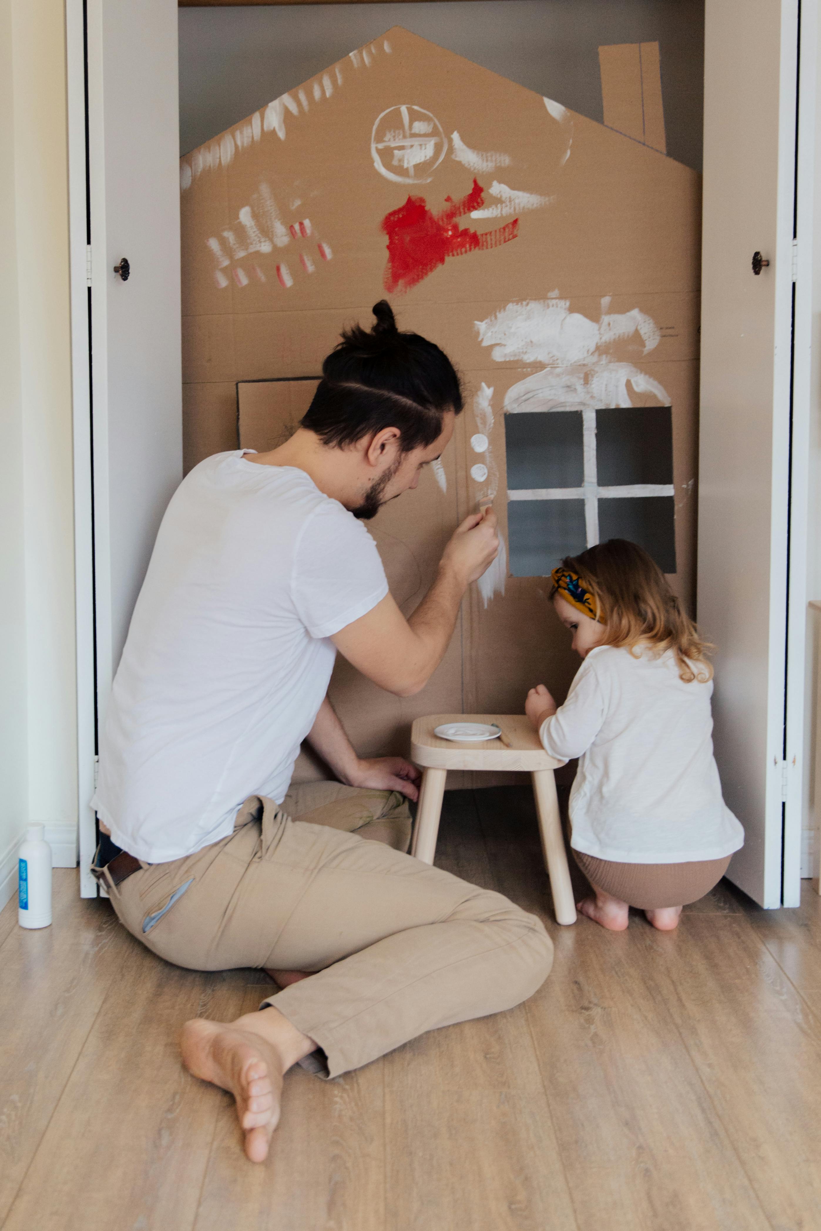 Father and child painting together